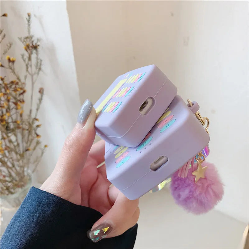 Purple silicone clamshell case for AirPods with fur ball pendant attached