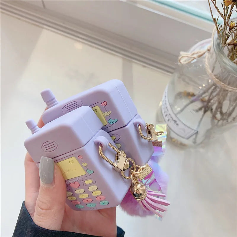 Purple silicone clamshell case for AirPods with fur ball pendant attached