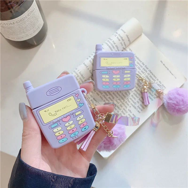Purple silicone clamshell case for AirPods with fur ball pendant attached