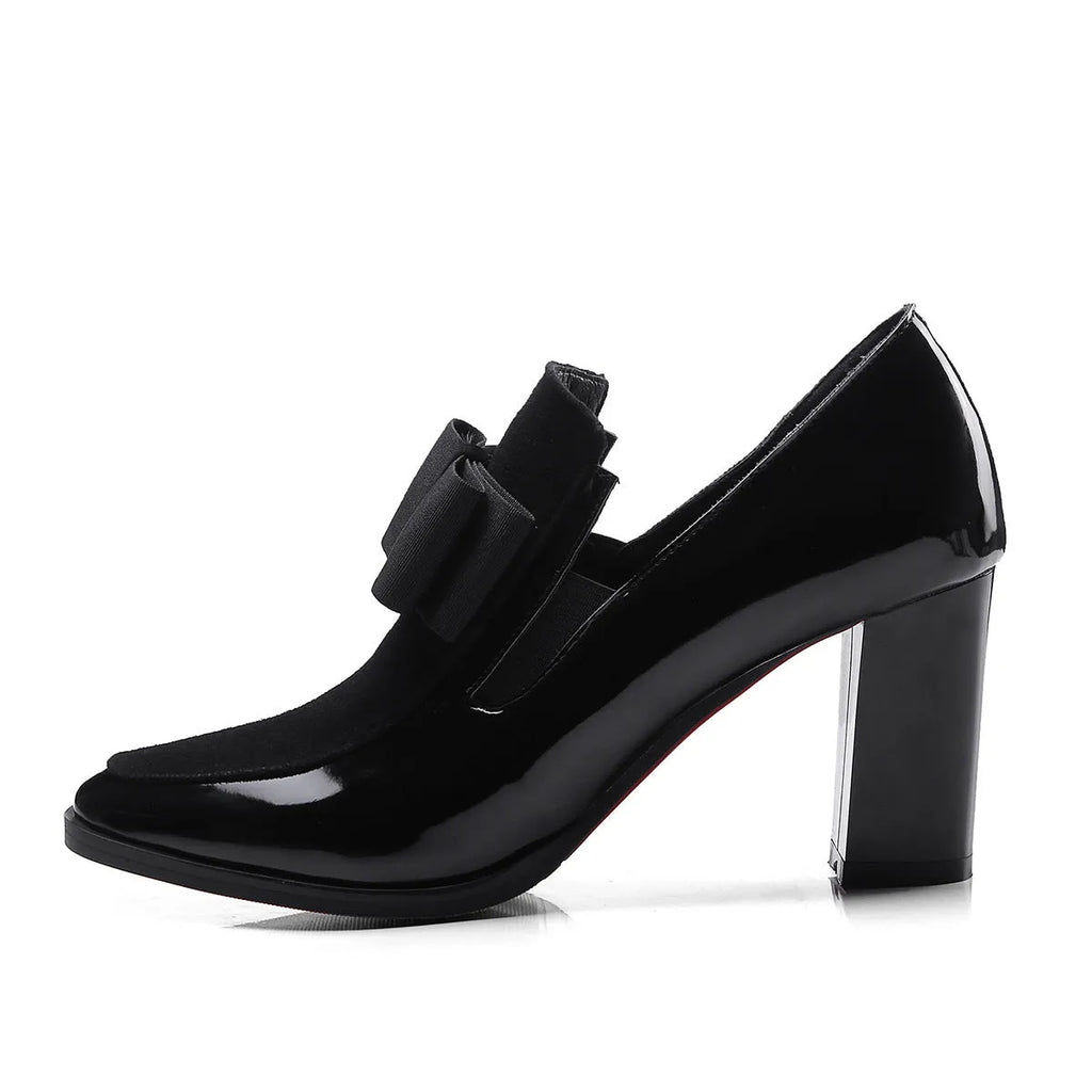 Black leather women's high heel shoes with a thick block heel and square toe, showing patent leather finish.