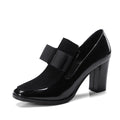 Black leather women's high heel shoes with a thick block heel and square toe, showing patent leather finish.