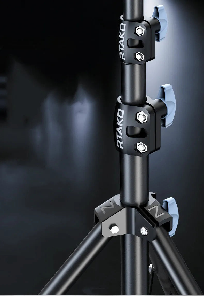 Carbon steel iPhone tripod stand with adjustable legs and a 10-inch ring light attached, next to its storage bag.
