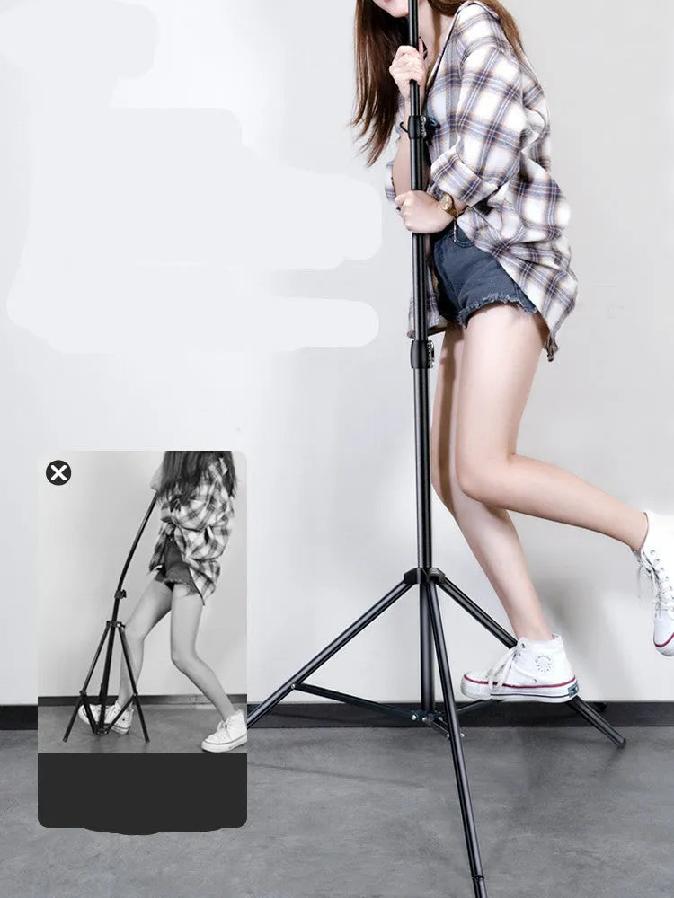 Carbon steel iPhone tripod stand with adjustable legs and a 10-inch ring light attached, next to its storage bag.