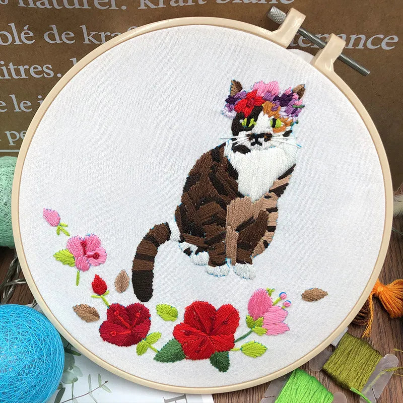 European embroidery starter kit showing pre-printed cat cross stitch design on fabric in a 15cm wooden hoop.