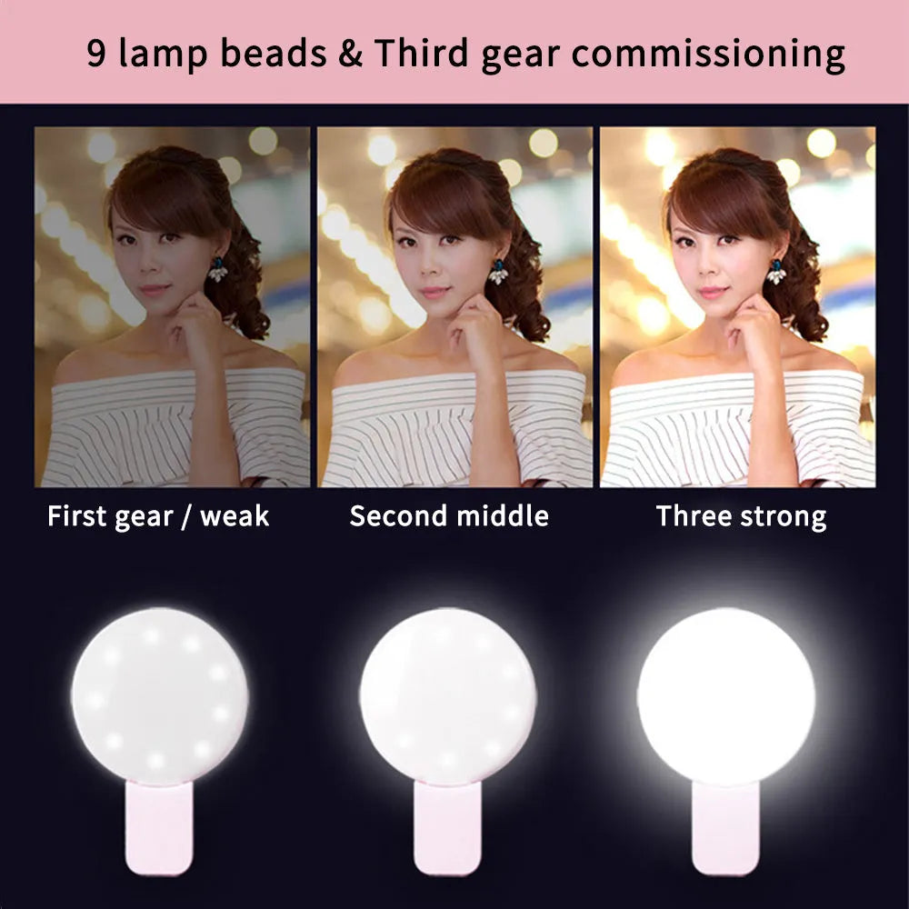 A small, round white clip-on LED fill light attached to a mobile phone for taking selfies.