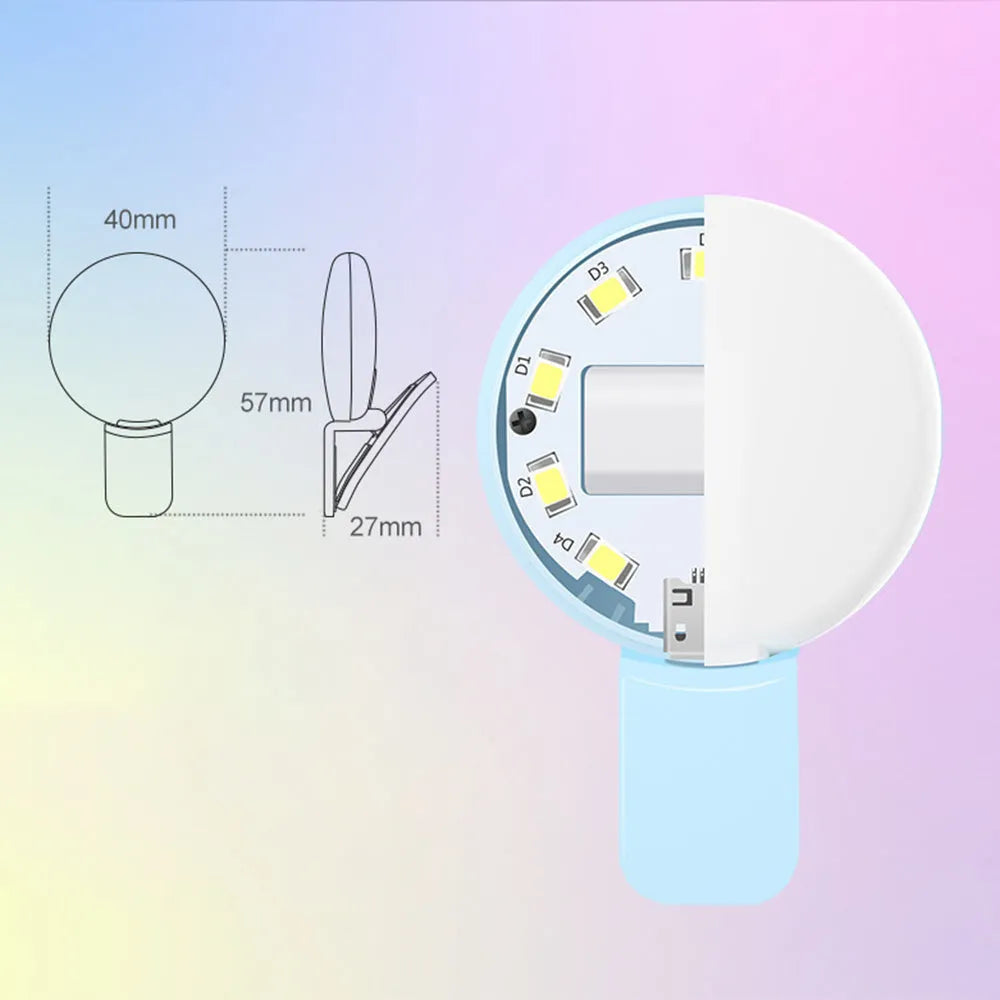 A small, round white clip-on LED fill light attached to a mobile phone for taking selfies.