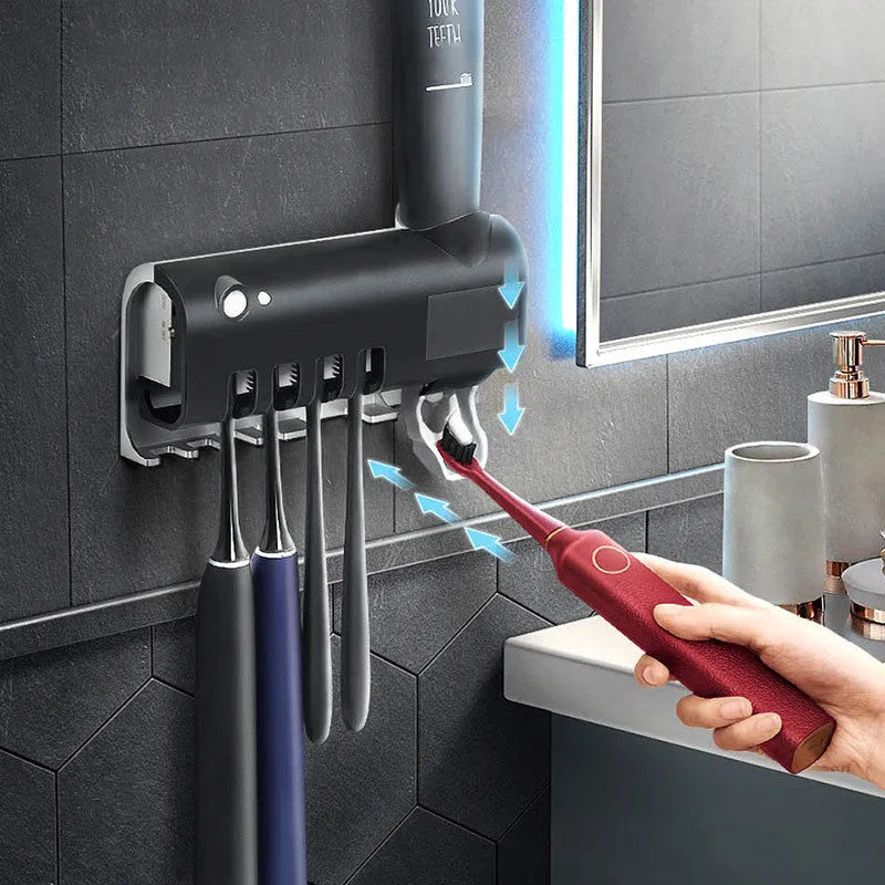 Wall-mounted UV toothbrush steriliser with automatic toothpaste squeezer and solar panel