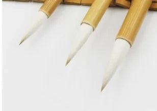 Three Chinese calligraphy brushes with bamboo handles and wool bristles shown in large, medium, and small sizes.