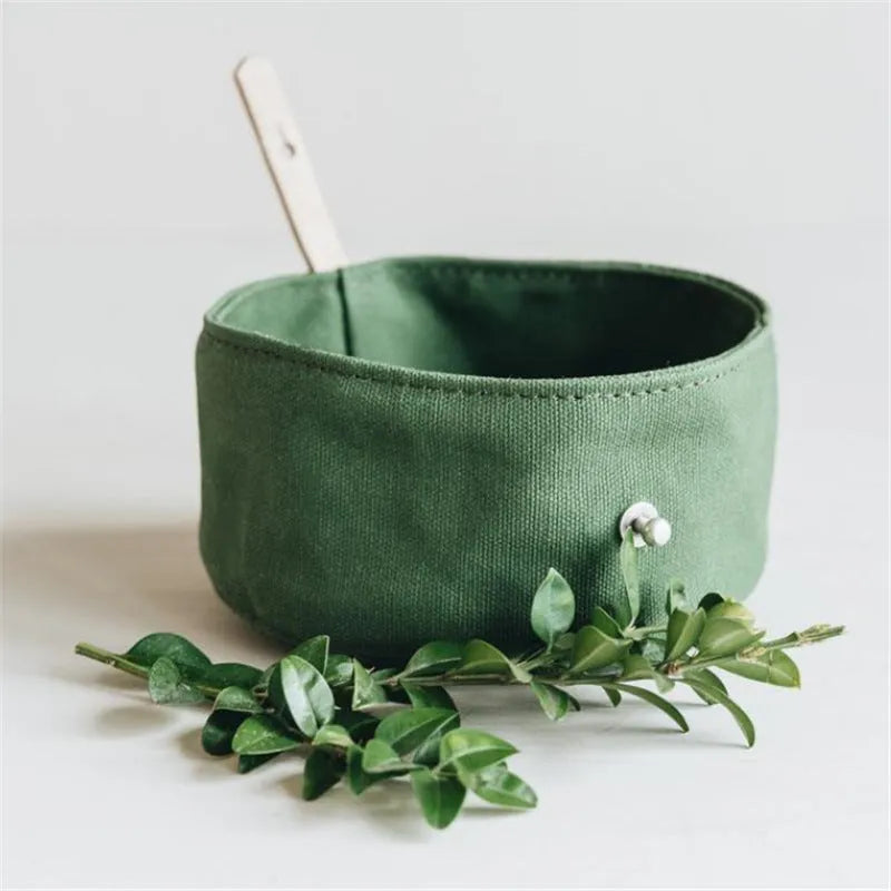Waterproof foldable travel dog bowl in oil wax canvas, round 150x75mm, shown in green or grey