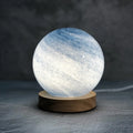 Nordic style table lamp with coloured glass shade on a bedside table