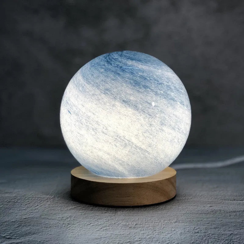Nordic style table lamp with coloured glass shade on a bedside table