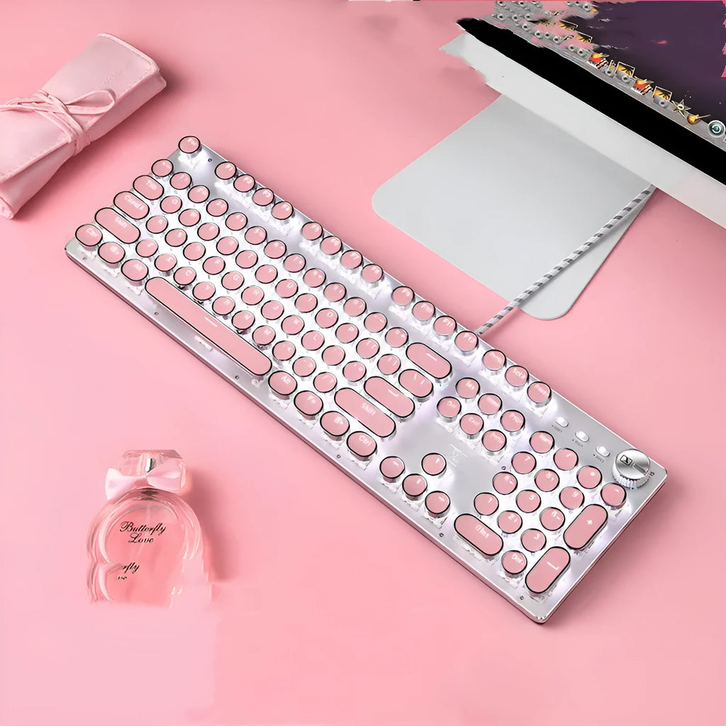 Queen Lipstick mechanical keyboard with green switches, silver bottom, and pink backlight on desk