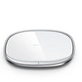 Black 15W square wireless charging pad with a glass top on a desk