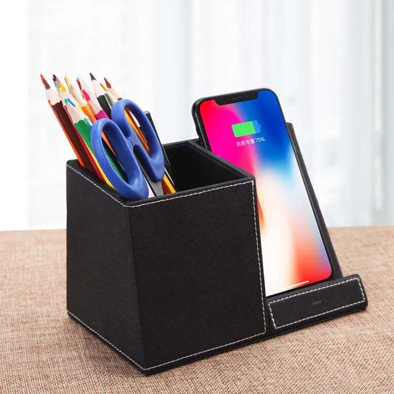 Black leather wireless charging station with pen holder slots showing phone charging on surface