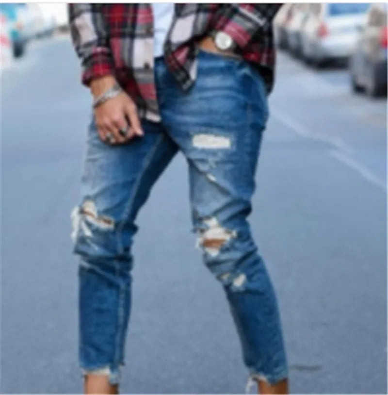 Men's distressed blue jeans with hole detailing on legs, cotton denim fabric