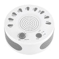 White noise sleep machine with volume knob, showing white colour option, beside USB cable on table