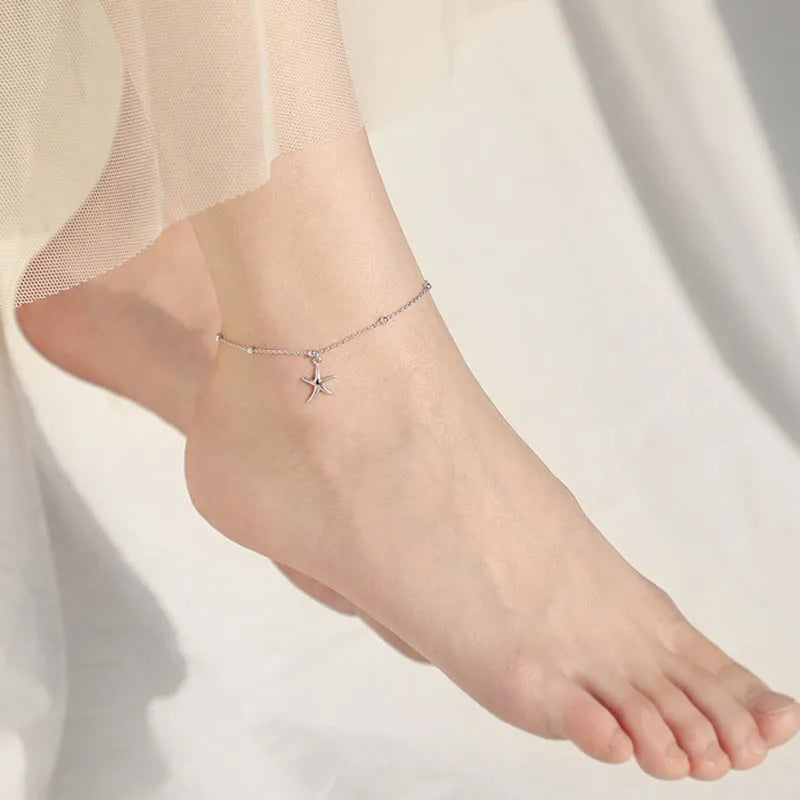 Close-up of a sterling silver starfish charm anklet with a round beaded chain.