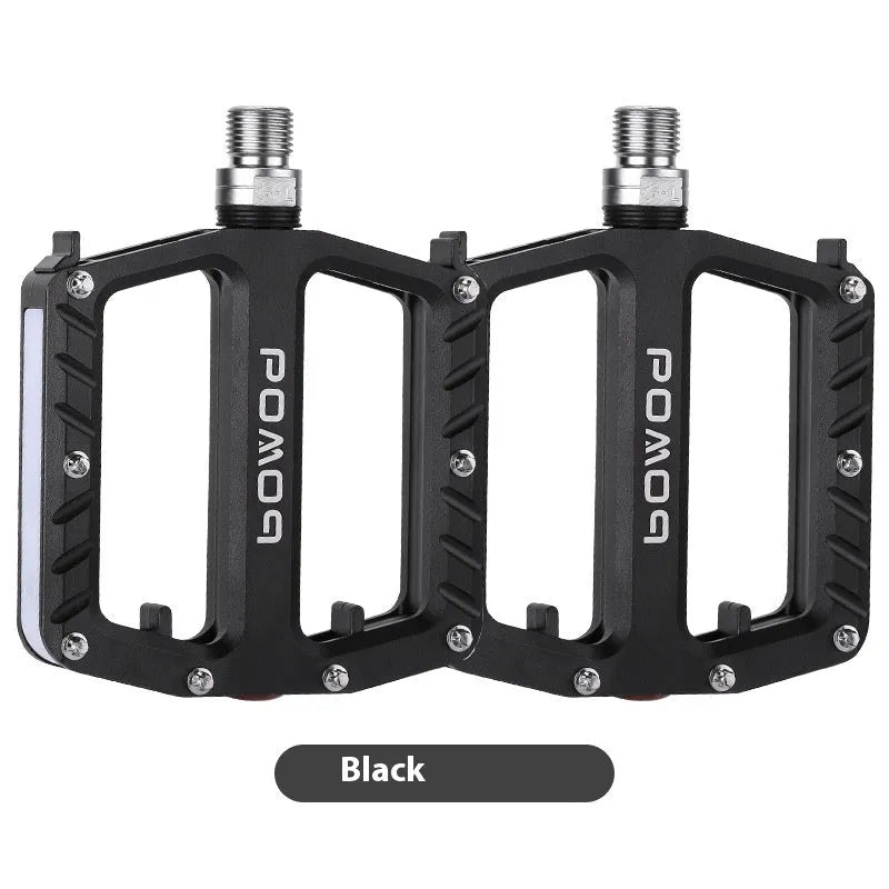 Aluminium alloy bicycle pedals with 710 LED lights in purple, black, titanium, red, and gold colours.