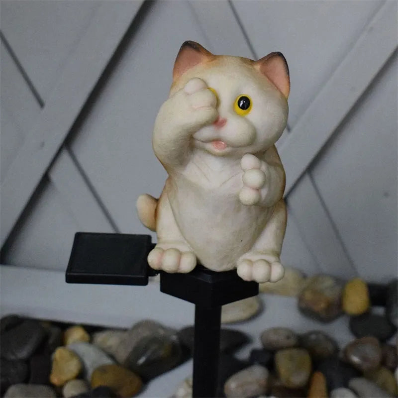 Brown resin cat-shaped solar garden light with LED on a lawn.