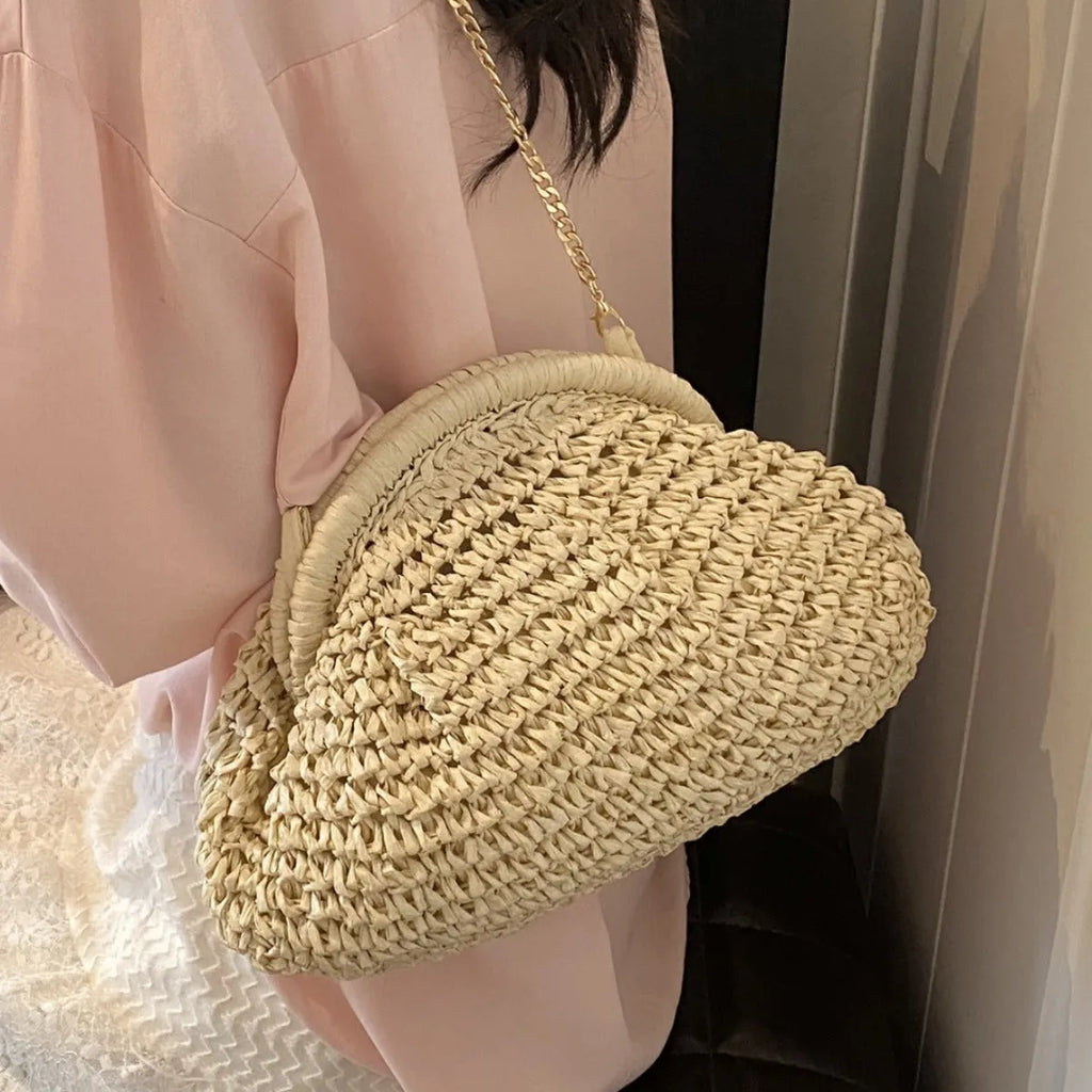 Women's straw handbag with shell shape, chain detail, and khaki colour option