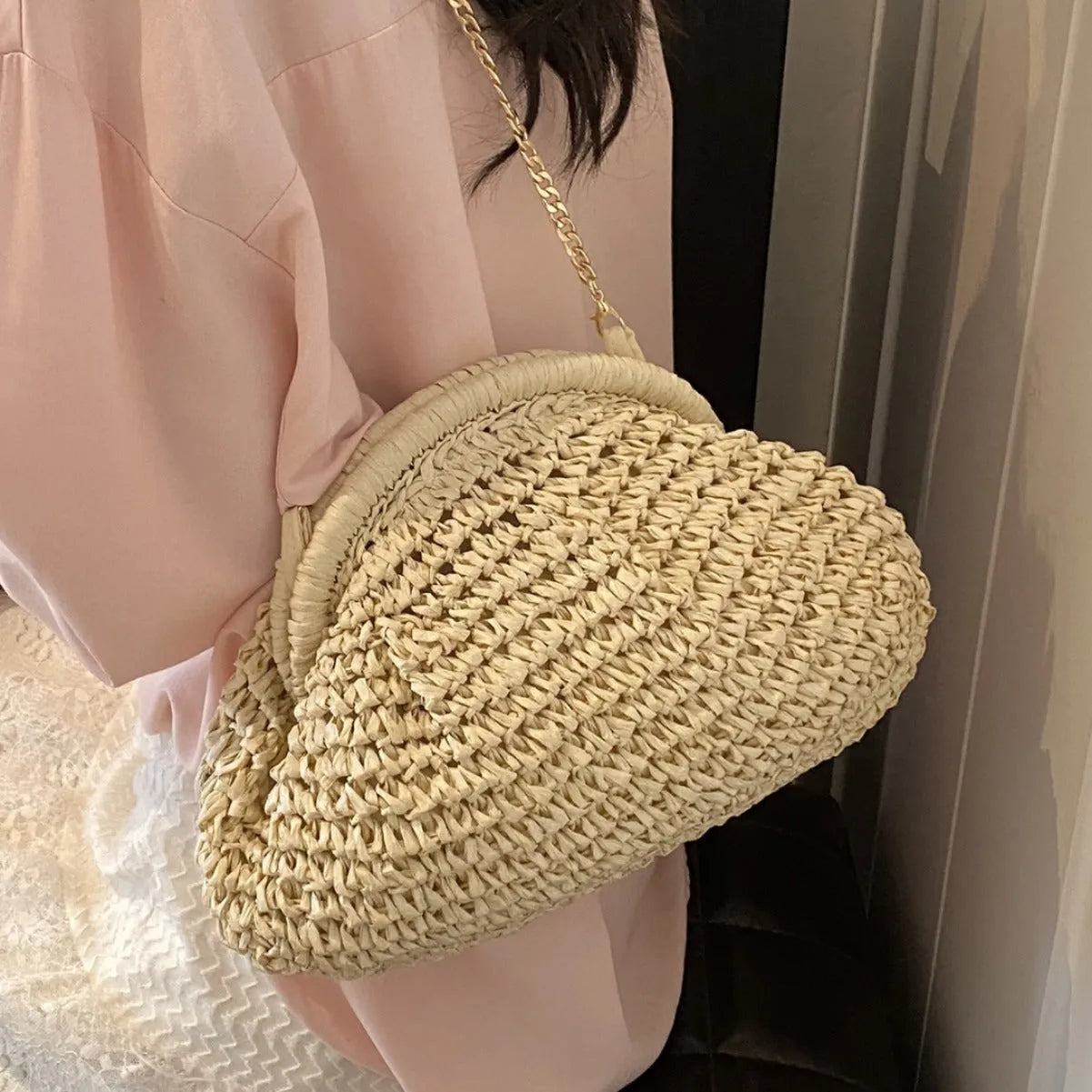 Women's straw handbag with shell shape, chain detail, and khaki colour option