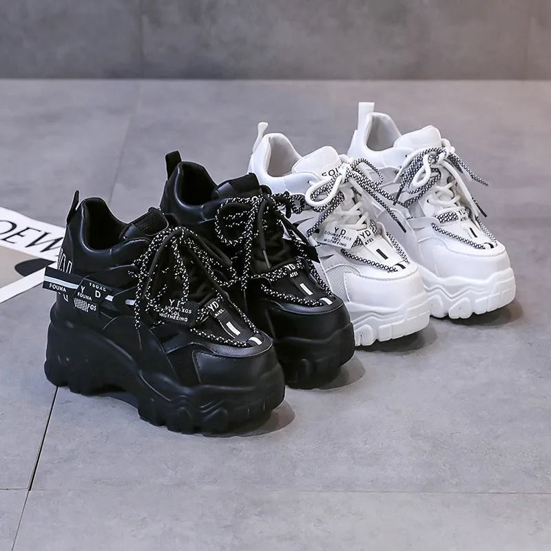 Women's white mesh platform trainers with cross-strap and chunky rubber sole on a neutral background.