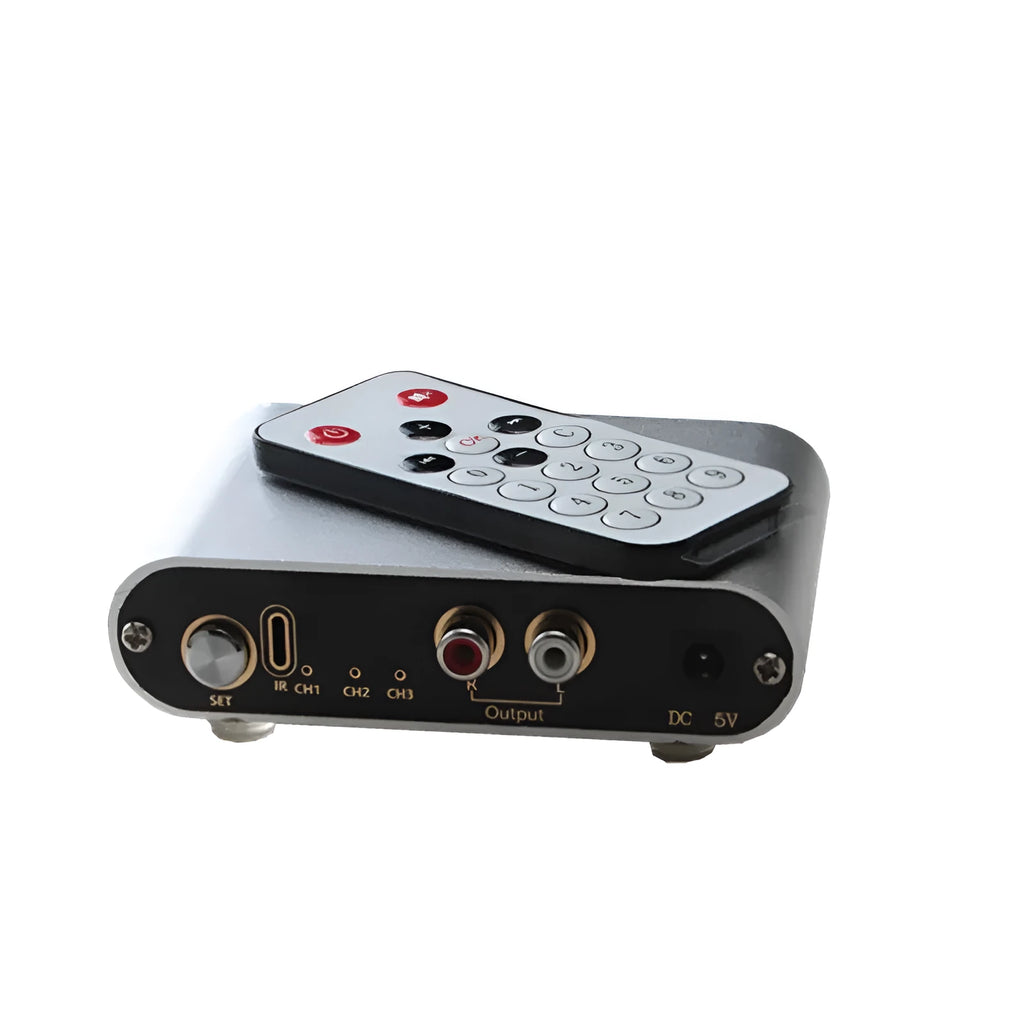 Silver aluminium audio source selector switch box with front button and infrared remote control.