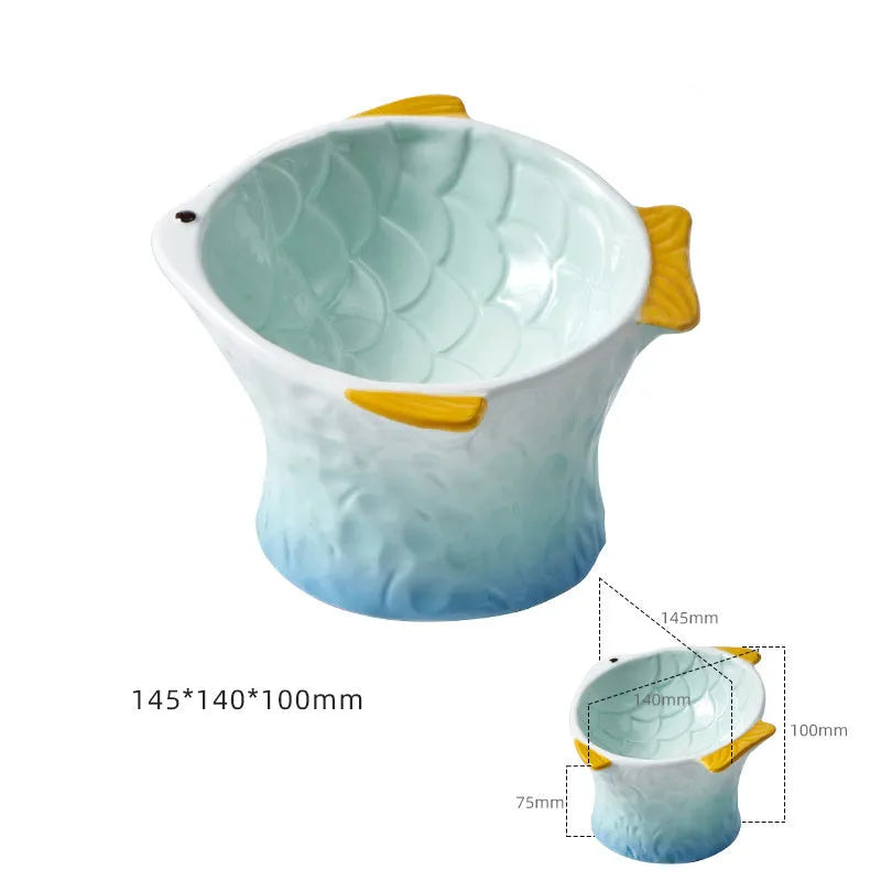 Four coloured fish-shaped ceramic pet bowls with a tilted, elevated design on a plain surface.
