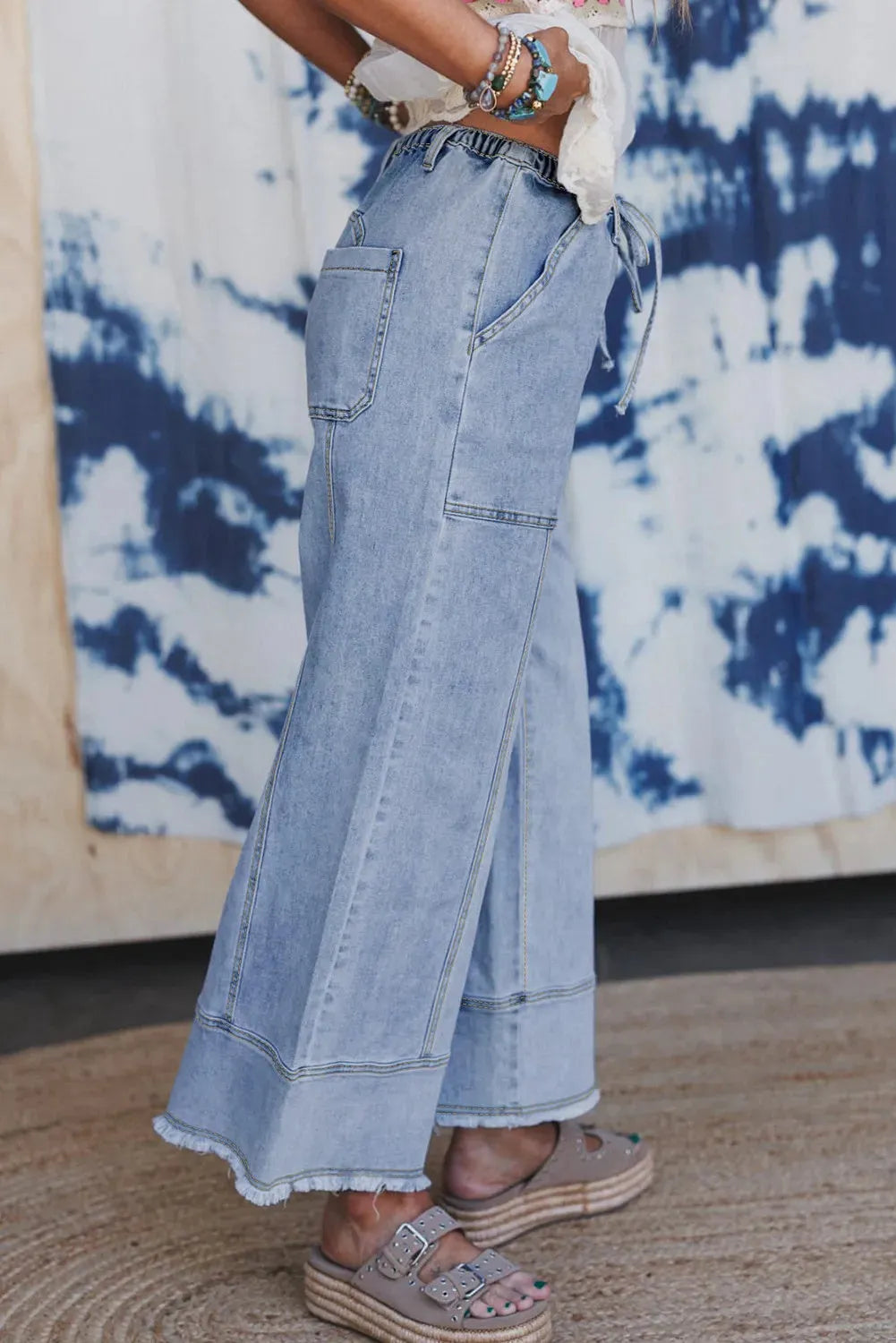 Beau blue wide leg women's denim trousers with a drawstring waist and raw hem detailing.