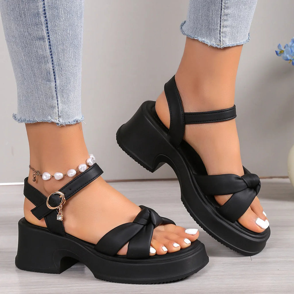 Black women's high heel slippers with thick platform sole and button closure.