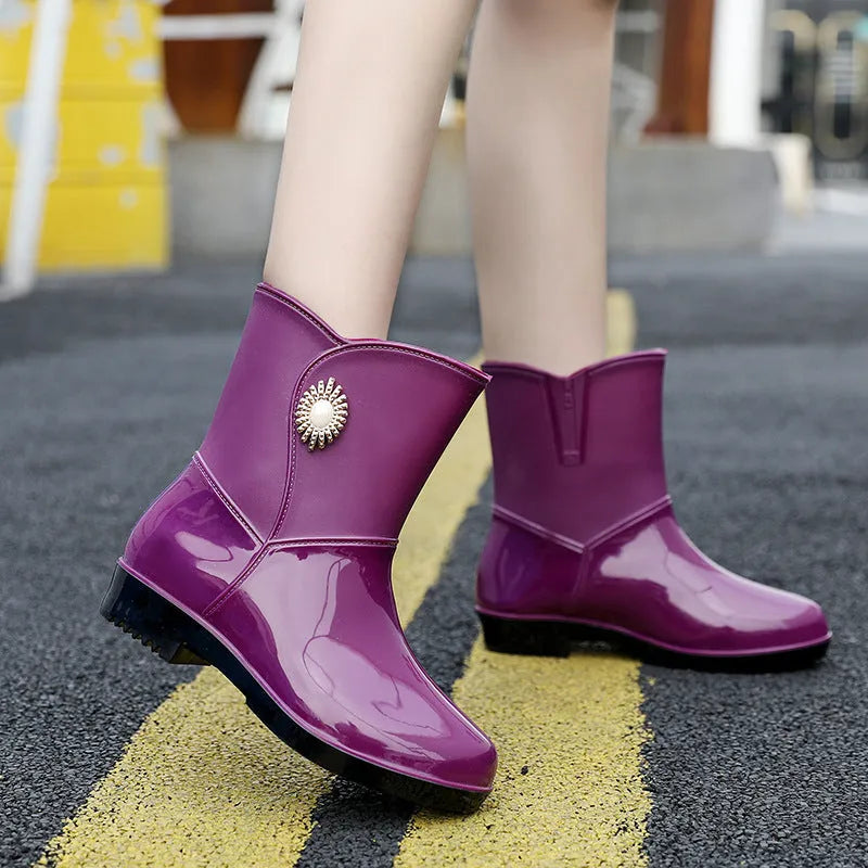 Women's middle tube PVC rain boots in beige, black, and purple with a non-slip sole.
