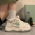 Women's green patent leather platform sneakers with white rubber sole and lace-up front.