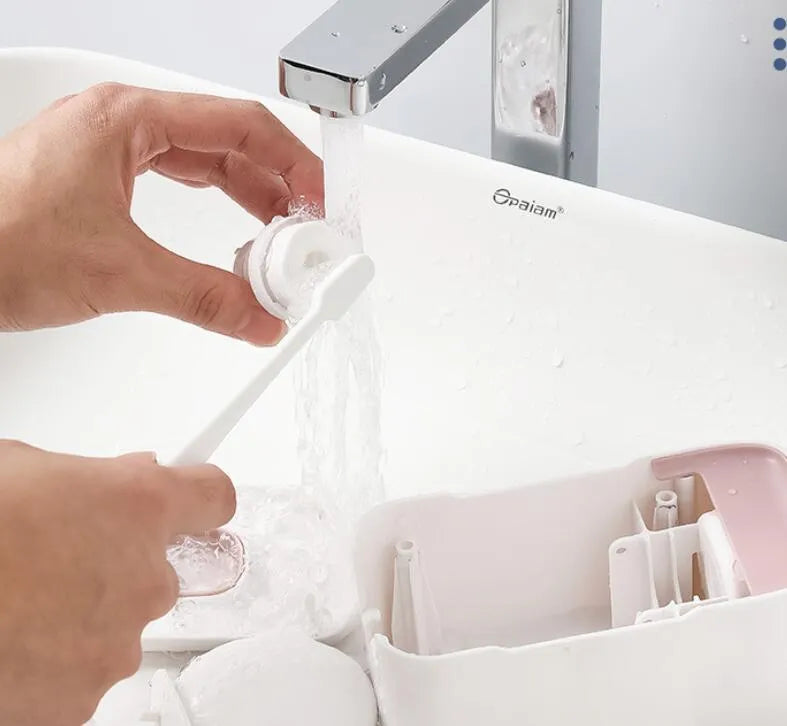 Wall-mounted automatic toothpaste dispenser in blue, grey, and pink colours