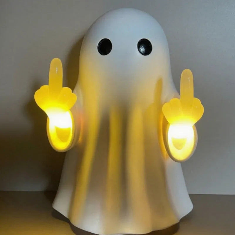 White ghost statue night lamp with LED light on a dark table.