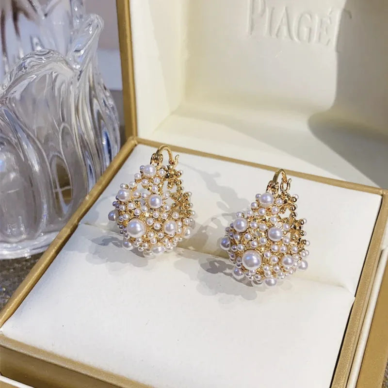 Gold-coloured copper flower basket earrings with small rice-shaped beads and pearl inlay detailing