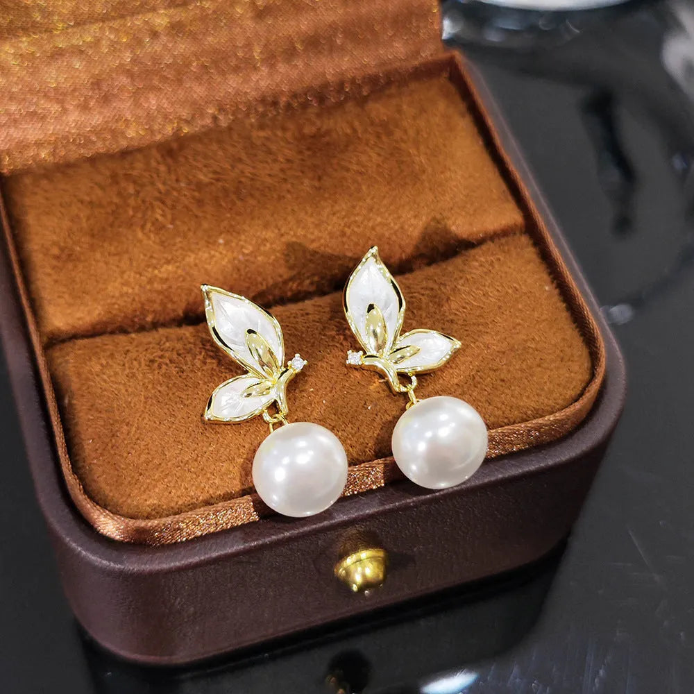 Close-up of a pair of zircon painting oil finish butterfly stud earrings on a copper base, style PT0203.