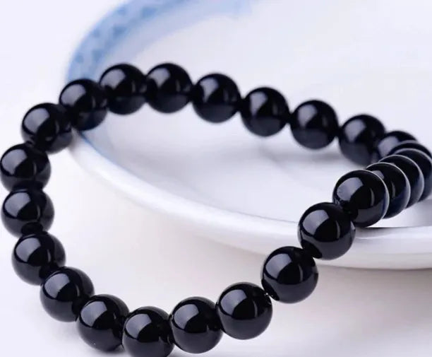 Black onyx bracelet with 8mm geometric agate beads on a black elastic cord.
