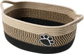 Light beige handmade cotton rope storage basket with wooden base and handle on a wooden floor