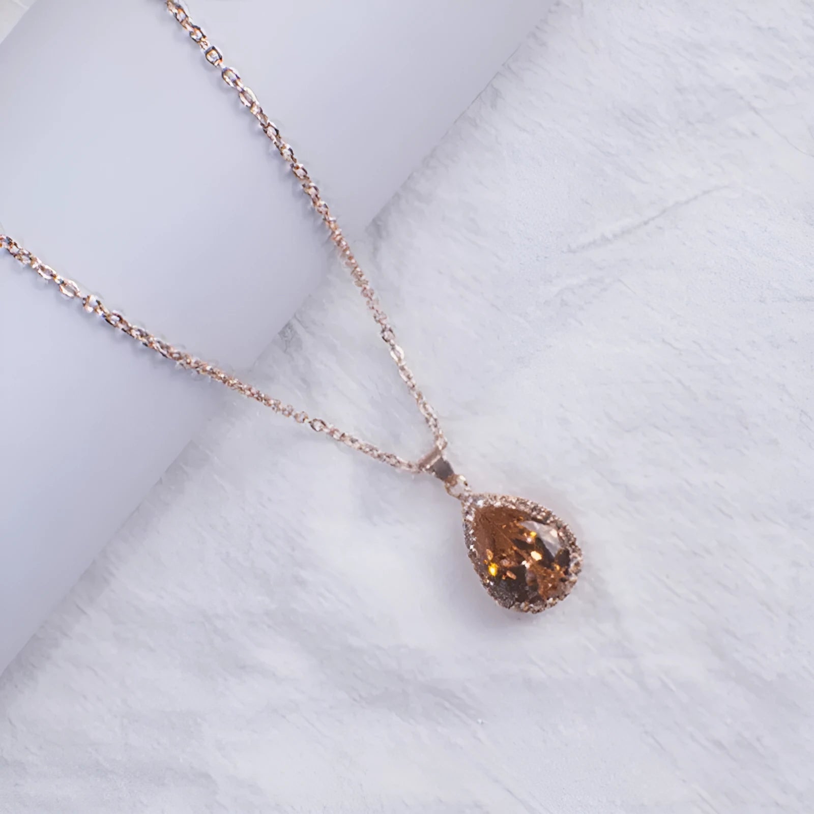 Drop-shaped pendant necklace with rhinestone and gemstone inlay in pink colour option