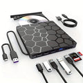 Black aluminium external USB CD drive and writer on a desk next to a laptop.