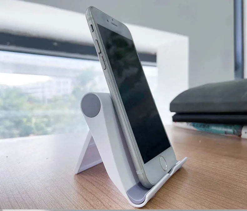Black PE folding phone and tablet stand on a desktop, adjusted to a viewing angle.