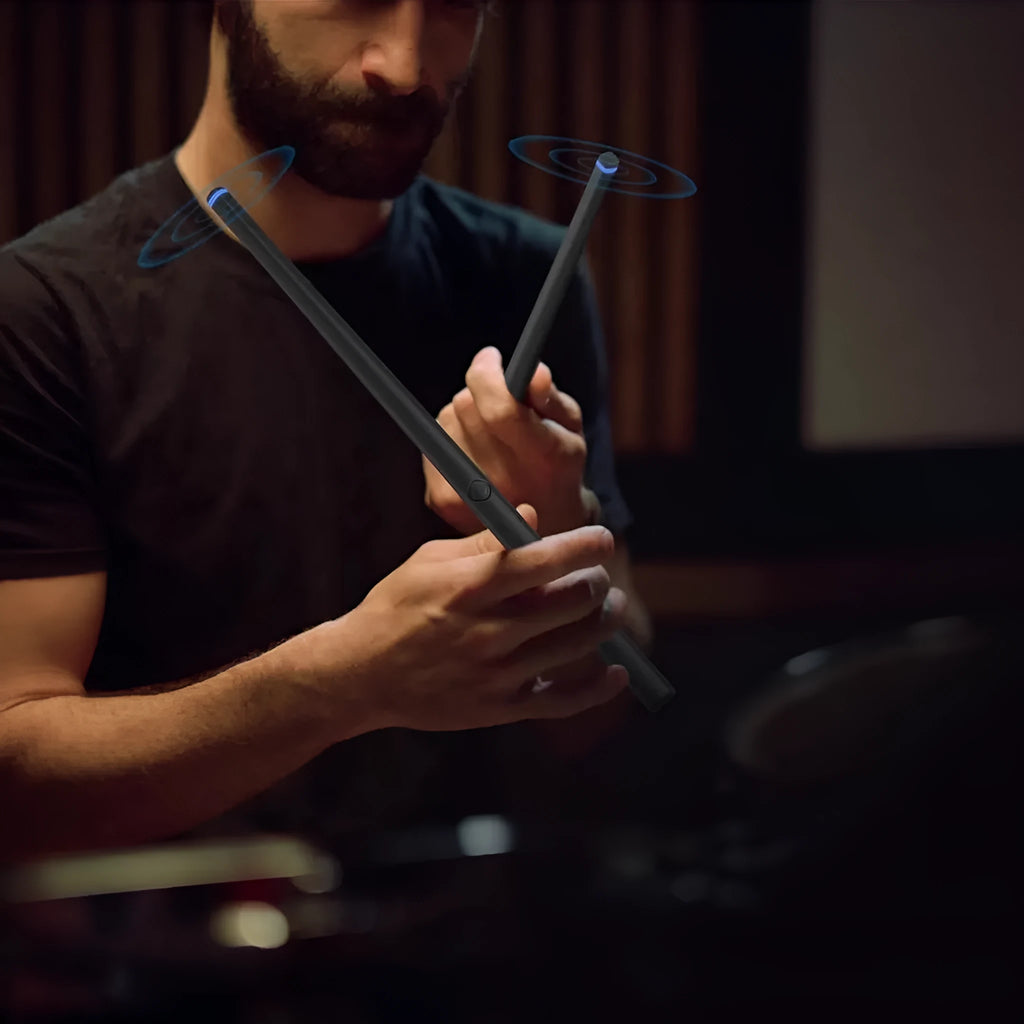 Black wireless somatosensory air drum kit host unit with drumsticks on a table.