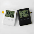 Black and white digital kitchen timer with magnetic back mounted on refrigerator