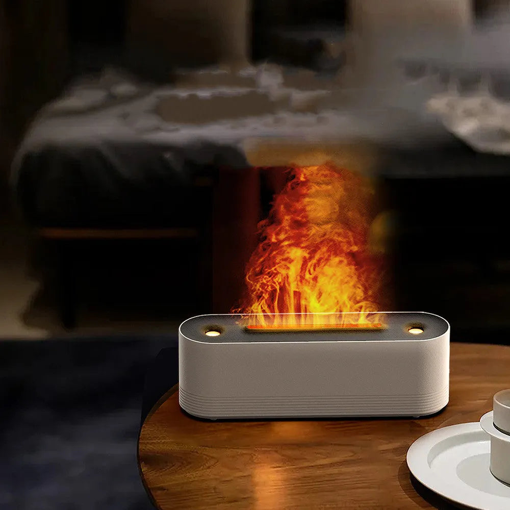 Tall black ultrasonic aroma diffuser with coloured flame LED light and rising water mist on a desk.