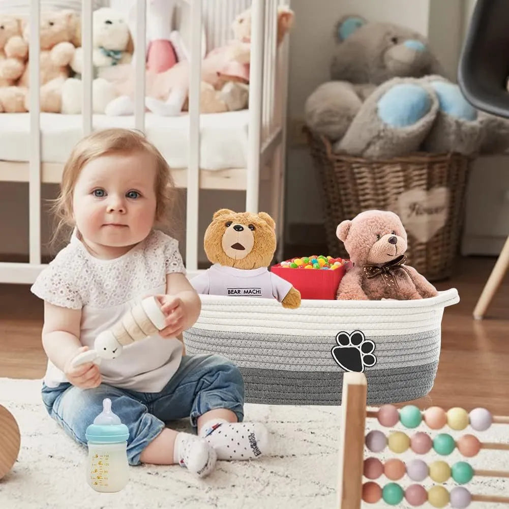 Light beige handmade cotton rope storage basket with wooden base and handle on a wooden floor