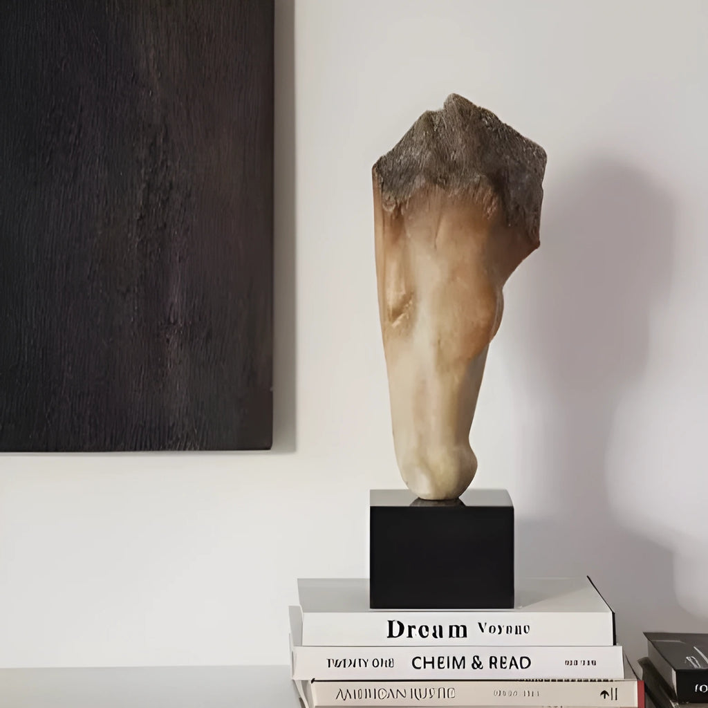 A tall, abstract white horse head sculpture with a carved surface texture on a shelf.