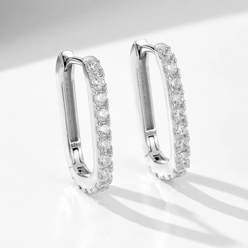 A pair of oval zircon clip earrings in sterling silver, shown in yellow and white finish options.
