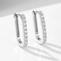 A pair of oval zircon clip earrings in sterling silver, shown in yellow and white finish options.