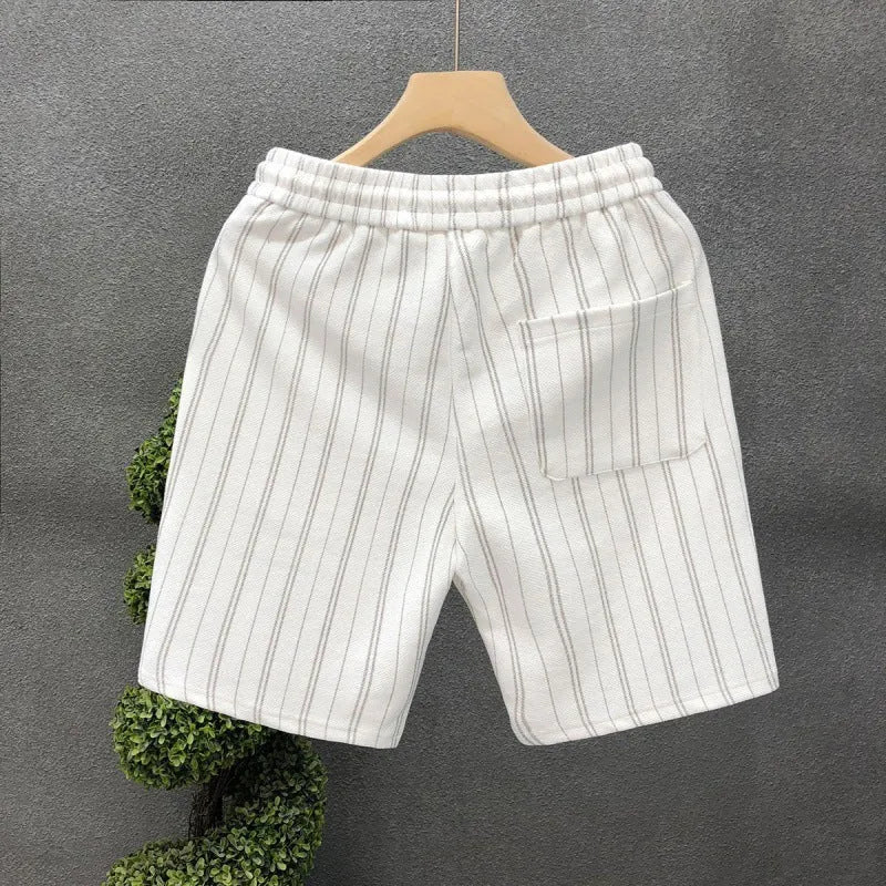 Man wearing black and white striped casual fleece-lined shorts with an elastic waistband.