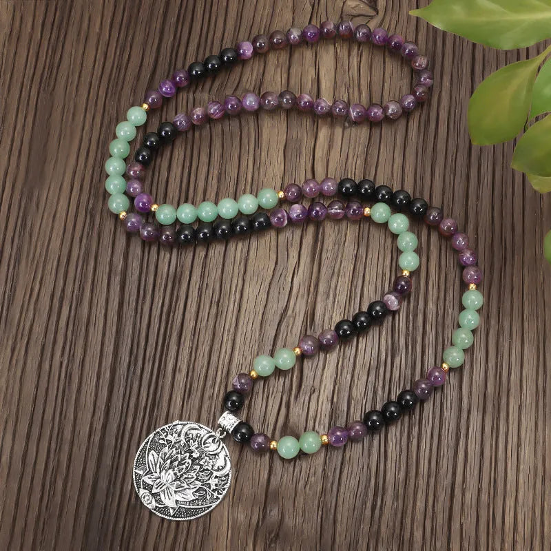 Long yoga lotus pendant necklace and matching bracelet set with stone beads and geometric design.